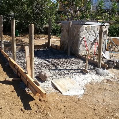 Concrete foundation with rebar mesh and stone wall